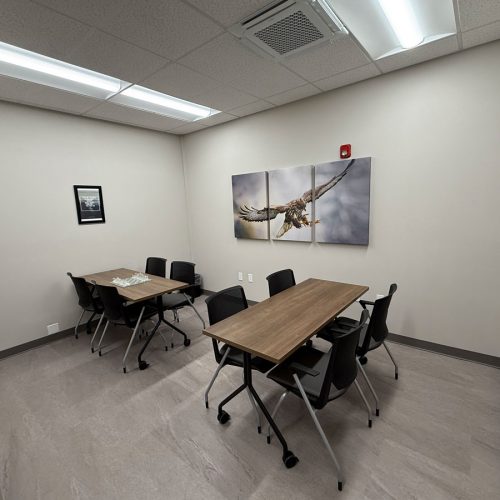 Large room with two rectangular tables and eight chairs.