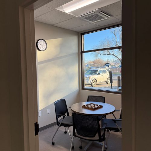 Room with windows, a small round table and four chairs.